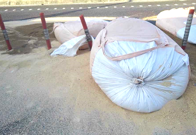 本線上に落下した砂袋と道路を埋めつくす大量の砂